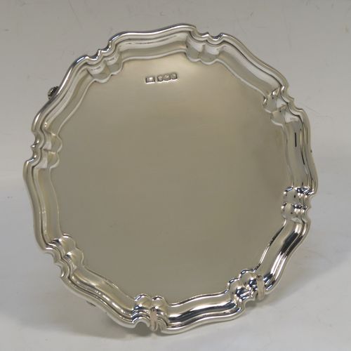 A very handsome Sterling Silver round salver, having a plain burnished ground, an applied Chippendale border, and sitting on four cast scroll feet. This elegant silver salver was made by the Atkin Brothers of Sheffield in 1925. The dimensions of this fine hand-made silver salver are diameter 15 cms (6 inches), and it weighs approx. 166g (5.4 troy ounces).   