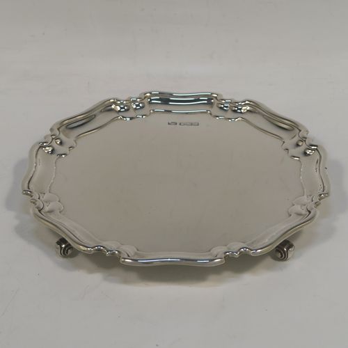 A very handsome Sterling Silver round salver, having a plain burnished ground, an applied Chippendale border, and sitting on four cast scroll feet. This elegant silver salver was made by the Atkin Brothers of Sheffield in 1925. The dimensions of this fine hand-made silver salver are diameter 15 cms (6 inches), and it weighs approx. 166g (5.4 troy ounces).   