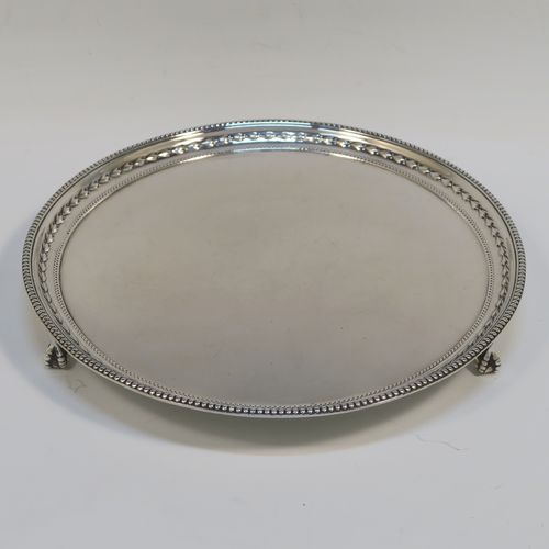 A very pretty Sterling Silver salver, having an applied bead-edged border above a hand-chased floral band, a plain ground, and sitting on three cast claw and ball feet. This beautiful silver salver was made by James Dixon and Sons of Sheffield in 1929. The dimensions of this fine hand-made silver salver are diameter 20 cms (8 inches), and it weighs approx. 307g (9.9 troy ounces).   