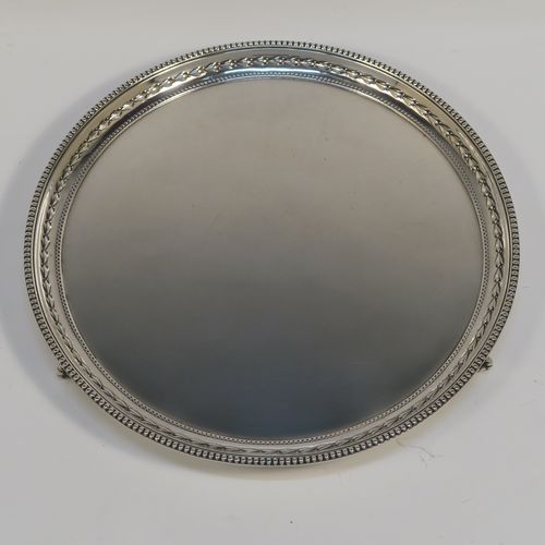 A very pretty Sterling Silver salver, having an applied bead-edged border above a hand-chased floral band, a plain ground, and sitting on three cast claw and ball feet. This beautiful silver salver was made by James Dixon and Sons of Sheffield in 1929. The dimensions of this fine hand-made silver salver are diameter 20 cms (8 inches), and it weighs approx. 307g (9.9 troy ounces).   