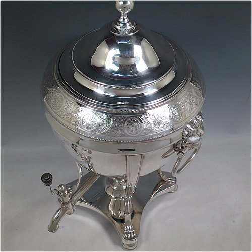 An Antique Georgian Old Sheffield plated urn-style samovar having a plain round body with applied gadroon borders, a band of hand-engraved floral decoration, and cast lion-mask handles. Having a lift-off lid with ball finial, a spigot with wooden finial, and all sitting on four lions-paw feet with a base that includes a removable burner and four ball feet. Made in ca. 1800. The dimensions of this fine hand-made Old Sheffield silver plated samovar are height 48 cms (19 inches), width 26 cms (10 inches), and depth incl. spigot 28 cms (11 inches).   