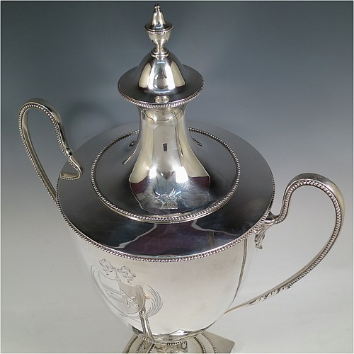 A very handsome Antique Georgian Neoclassical style Sterling Silver samovar, having a plain urn-shaped body, with pull-off lid and finial, two side-handles, an original spigot with bone handle, all with applied bead-edged borders, and all sitting on a pedestal foot with a square base. Please note that this piece has an unusual heating mechanism where the main body detaches from the foot allowing for the insertion of a heated piece of pig-iron. Made by John Denziloe of London in 1783. The dimensions of this fine hand-made antique silver samovar are height 52 cms (20.5 inches), width 33 cms (13 inches), and it weighs approx. 3,112g (100 troy ounces). Please note that this item is crested.  