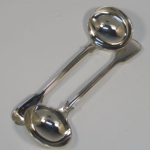 A beautiful Antique Victorian Sterling Silver pair of sauce ladles in the double-struck Fiddle and Thread pattern, having oval bowls. These elegant silver sauce ladles were made by the most important Victorian cutlery maker, George Adams, of London in 1845. The dimensions of this fine pair of hand-made antique silver sauce ladles are length 18.5 cms (7.25 inches), and they weigh a total of approx. 148g (4.8 troy ounces).   