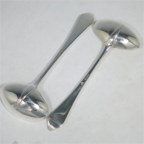 A Sterling Silver pair of Sauce Ladles in the plain Dog-nose pattern with Rattail on reverse, and oval bowls. Made by Goldsmiths & Silversmiths of London in 1917. The dimensions of this fine pair of hand-made silver sauce ladles are length 18 cms (7 inches), and they weigh a total of approx. 155g (5 troy ounces).    