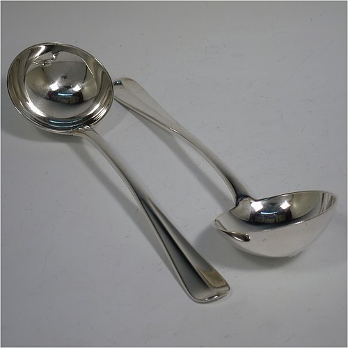 A very handsome Antique Edwardian Sterling Silver pair of Sauce Ladles in the Hollow-Ribbed Rattail pattern, and having round bowls. These elegant antique silver sauce ladles were made by Johnson, Walker, and Tolhurst of London in 1908. The dimensions of this fine pair of hand-made silver sauce ladles are length 18 cms (7 inches), and they weigh a total of approx. 136g (4.4 troy ounces).    