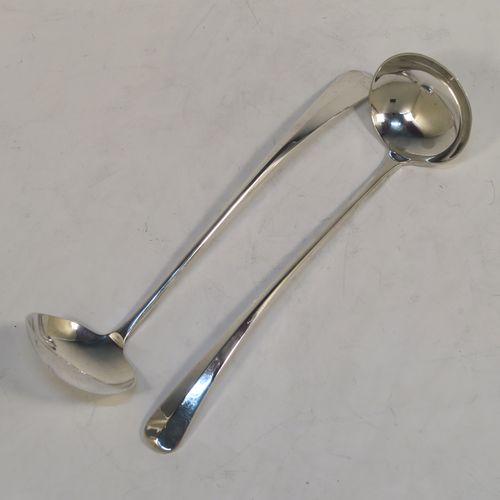 An unusual pair of long-handled Sterling Silver sauce or cream Ladles in the Rattail Hanoverian pattern, having plain round bowls, and long plain handles. This elegant pair of silver ladles were made by Robert Comyns of London in 1975. The dimensions of this fine pair of hand-made silver cream or sauce ladles are length 18 cms (7 inches), and they weigh a total of approx. 98g (3.2 troy ounces).   