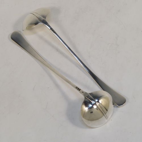 An unusual pair of long-handled Sterling Silver sauce or cream Ladles in the Rattail Hanoverian pattern, having plain round bowls, and long plain handles. This elegant pair of silver ladles were made by Robert Comyns of London in 1975. The dimensions of this fine pair of hand-made silver cream or sauce ladles are length 18 cms (7 inches), and they weigh a total of approx. 98g (3.2 troy ounces).   