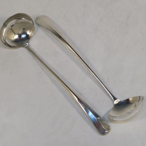 An unusual pair of long-handled Sterling Silver sauce or cream Ladles in the Rattail Hanoverian pattern, having plain round bowls, and long plain handles. This elegant pair of silver ladles were made by Robert Comyns of London in 1975. The dimensions of this fine pair of hand-made silver cream or sauce ladles are length 18 cms (7 inches), and they weigh a total of approx. 98g (3.2 troy ounces).   