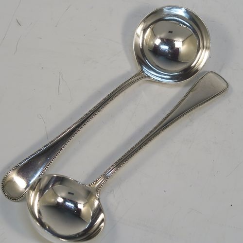 A beautiful Antique Victorian Sterling Silver pair of sauce ladles in the double-struck bead pattern, having round bowls. These elegant silver sauce ladles were made by the most important Victorian cutlery maker, George Adams, of London in 1864. The dimensions of this fine pair of hand-made antique silver sauce ladles are length 18.5 cms (7.25 inches), and they weigh a total of approx. 157g (5 troy ounces).  