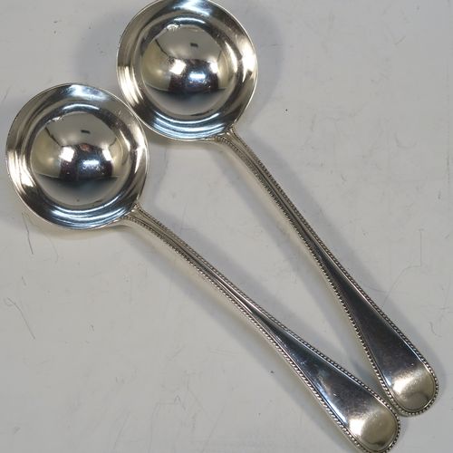 A beautiful Antique Victorian Sterling Silver pair of sauce ladles in the double-struck bead pattern, having round bowls. These elegant silver sauce ladles were made by the most important Victorian cutlery maker, George Adams, of London in 1864. The dimensions of this fine pair of hand-made antique silver sauce ladles are length 18.5 cms (7.25 inches), and they weigh a total of approx. 157g (5 troy ounces).  