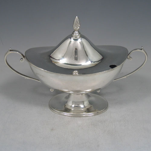 Antique Victorian sterling silver sauce tureen and cover, having a plain oval body, reeded borders, two scroll handles, a pull-off lid with flame finial, and all sitting on a pedestal foot. Made by Nathan and Hayes of Chester in 1901. Height 16 cms (6.25 inches), length 23 cms (9 inches), width 9 cms (3.5 inches). Weight approx. 360g (11.6 troy ounces).