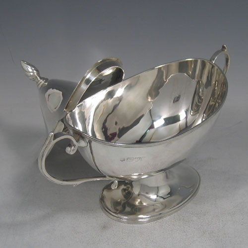 Antique Victorian sterling silver sauce tureen and cover, having a plain oval body, reeded borders, two scroll handles, a pull-off lid with flame finial, and all sitting on a pedestal foot. Made by Nathan and Hayes of Chester in 1901. Height 16 cms (6.25 inches), length 23 cms (9 inches), width 9 cms (3.5 inches). Weight approx. 360g (11.6 troy ounces).