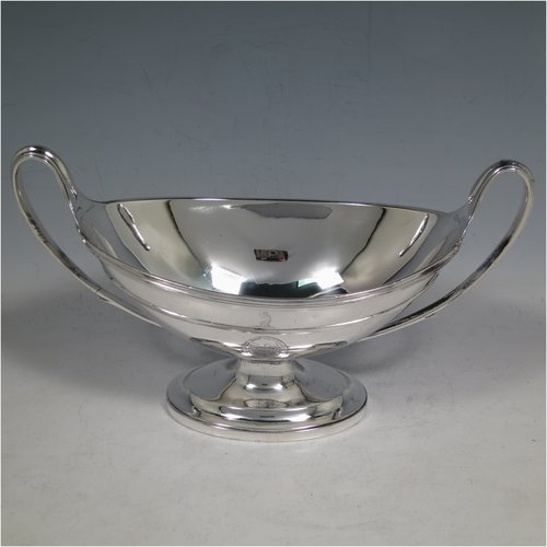 An Antique Georgian Sterling Silver pair of heavy sauce tureens, having oval neoclassical boat-shaped bodies with applied reeded borders, with cast reeded loop handles, and all sitting on cast oval pedestal feet. Made by Cornelius Bland y of London in 1792. The dimensions of this fine hand-made antique silver pair of sauce tureens are height 14 cms (5.5 inches), length 24.5 cms (9.75 inches), width 11 cms (4.25 inches), with a total weight of approx. 960g (31 troy ounces). Please note that both theses items are crested.  