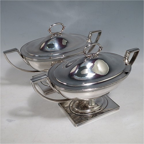 An Antique Georgian Old Sheffield silver-plated pair of Neoclassical sauce tureens, having oval boat-shaped bodies with applied reeded borders, with cast reeded side-handles, original domed lids with asparagus loop handles, and all sitting on pedestal feet with rectangular bases. Made in ca. 1790 in the Old Sheffield fused plate. The dimensions of this fine hand-made antique Old Sheffield silver plated pair of sauce tureens are height 14 cms (5.5 inches), length 23 cms (9 inches), and width 11 cms (4.25 inches).   