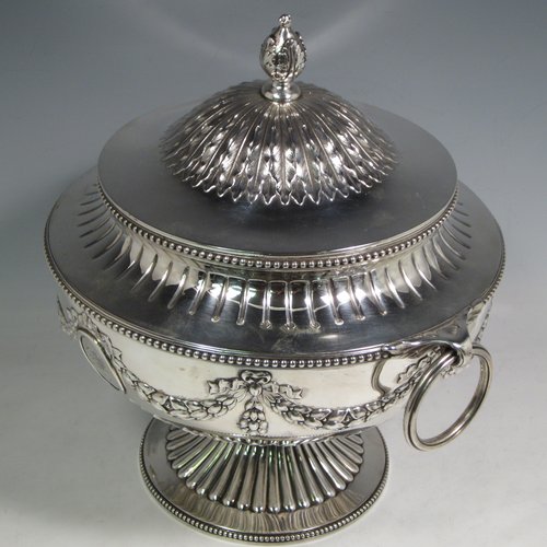 Antique Victorian sterling silver suite of soup and sauce tureens with covers, having round bodies with bead-edged borders, with hand-chased neoclassical style decoration, lift-off lids with anthemion leaves and cast floral finials, side  handles with attached rings, and all sitting on pedestal feet. Made by Robert Hennell II of London in 1872. The dimensions of the fine larger silver tureen are height 27 cms (10.5 inches), diameter length 23 cms (9 inches), with a total weight of approx. 2,356g (76 troy ounces). Please note that these items are crested in one cartouche. 