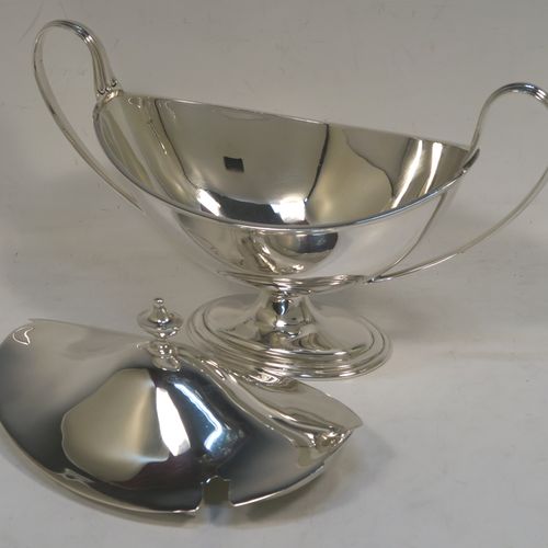 A very elegant Sterling Silver pair of sauce tureens with covers, having plain oval neoclassical boat-shaped bodies with applied reeded borders, pull-off lids with cast finials,  with reeded loop side-handles, and all sitting on pedestal feet. These beautiful silver sauce tureens were made by Thomas Bradbury of Sheffield in 1931. The dimensions of this fine hand-made silver2 pair of sauce tureens are height 13.5 cms (5.5 inches), length 23 cms (9 inches), width 10 cms (4 inches), with a total weight of approx. 853g (27.5 troy ounces).    