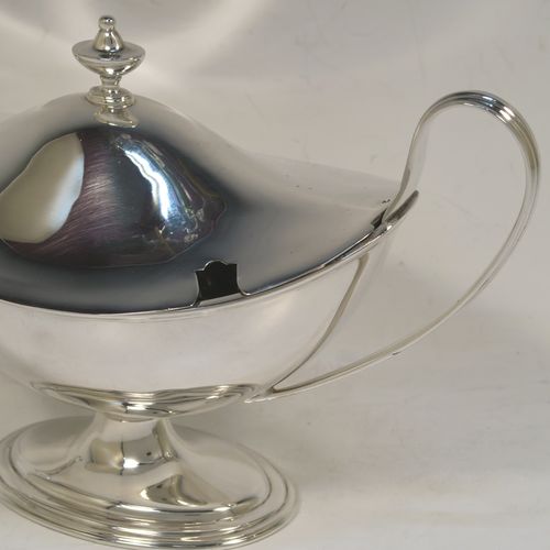 A very elegant Sterling Silver pair of sauce tureens with covers, having plain oval neoclassical boat-shaped bodies with applied reeded borders, pull-off lids with cast finials,  with reeded loop side-handles, and all sitting on pedestal feet. These beautiful silver sauce tureens were made by Thomas Bradbury of Sheffield in 1931. The dimensions of this fine hand-made silver2 pair of sauce tureens are height 13.5 cms (5.5 inches), length 23 cms (9 inches), width 10 cms (4 inches), with a total weight of approx. 853g (27.5 troy ounces).    