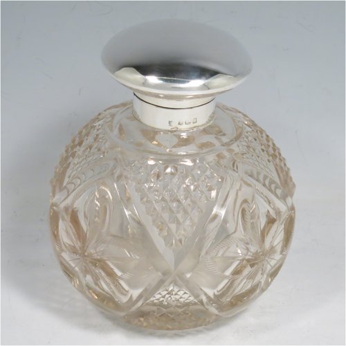 An Antique Sterling Silver and hand-cut crystal large table scent bottle, having a plain round mount, a hinged lid, an internal stopper, and hand-cut main body with hobnail and leaf patterns. Made by Charles S. Green & Co., of Birmingham in 1912. The dimensions of this fine hand-made scent bottle are height 11.5 cms (4.5 inches), and diameter 9.5 cms (3.75 inches).    