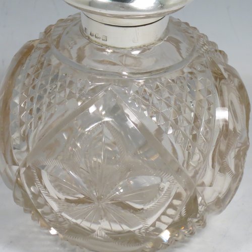 An Antique Sterling Silver and hand-cut crystal large table scent bottle, having a plain round mount, a hinged lid, an internal stopper, and hand-cut main body with hobnail and leaf patterns. Made by Charles S. Green & Co., of Birmingham in 1912. The dimensions of this fine hand-made scent bottle are height 11.5 cms (4.5 inches), and diameter 9.5 cms (3.75 inches).    