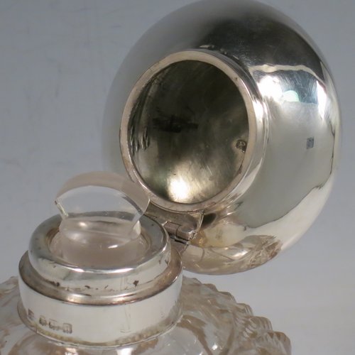 An Antique Sterling Silver and hand-cut crystal large table scent bottle, having a plain round mount, a hinged lid, an internal stopper, and hand-cut main body with hobnail and leaf patterns. Made by Charles S. Green & Co., of Birmingham in 1912. The dimensions of this fine hand-made scent bottle are height 11.5 cms (4.5 inches), and diameter 9.5 cms (3.75 inches).    