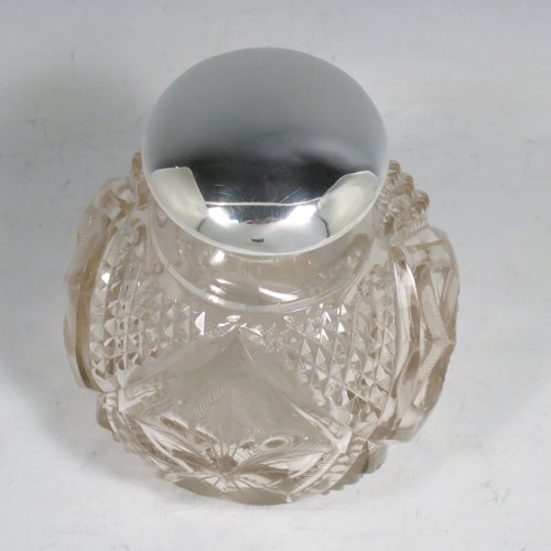 An Antique Sterling Silver and hand-cut crystal large table scent bottle, having a plain round mount, a hinged lid, an internal stopper, and hand-cut main body with hobnail and leaf patterns. Made by Charles S. Green & Co., of Birmingham in 1912. The dimensions of this fine hand-made scent bottle are height 11.5 cms (4.5 inches), and diameter 9.5 cms (3.75 inches).    