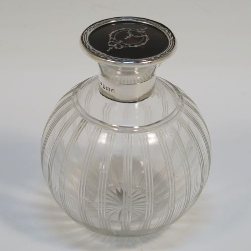 A very pretty Sterling Silver and inlaid tortoise-shell hand-cut crystal table scent bottle, having a plain round mount, a hinged lid with an inlaid tortoise-shell cover, an internal stopper, and hand-cut main body with reeding and star-cut decoration. This beautiful silver and crystal scent bottle was made by Hasset and Harper Ltd., of Birmingham in 1921. The dimensions of this fine hand-made silver and tortoise shell scent bottle are height 10 cms (4 inches), and diameter 9 cms (3.5 inches).   