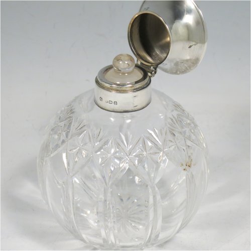 A Sterling Silver and hand-cut crystal table scent bottle, having a plain round mount, a hinged lid with a blue enamelled top, an internal stopper, and hand-cut main body with reeding and star-cut  decoration. Made by Albert Carter of Birmingham in 1926. The dimensions of this fine hand-made silver and enamelled scent bottle are height 11 cms (4.25 inches), and diameter 9 cms (3.5 inches).    