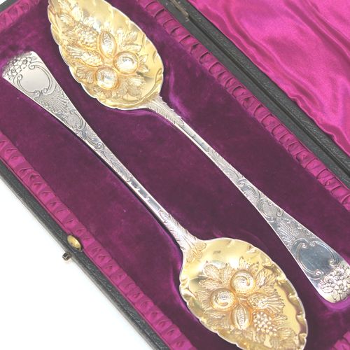 A very pretty pair of Antique Georgian Sterling Silver and gold-gilt berry serving spoons, having hand-chased handles with floral decoration, and gold-gilt hand-chased fluted bowls with fruit decoration, all in their original maroon satin and velvet-lined presentation box. These beautiful antique silver berry serving spoons were made by Josiah and George Piercy of London in 1819. The dimensions of this fine hand-made pair of antique silver berry spoons are length 23cms (9 inches), and they weigh a total of approx. 111g (3.6 troy ounces).   