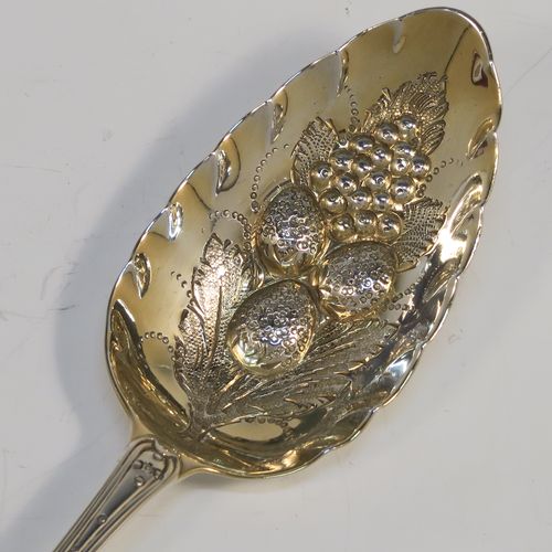 A very pretty pair of Antique Georgian Sterling Silver berry serving spoons, having hand-chased handles with floral decoration, and hand-chased gold-gilt bowls with fluted and fruit decoration, all in a cream satin and maroon velvet-lined presentation box. These beautiful silver serving spoons were made by Smith and Fern of London in 1795. The dimensions of this fine hand-made pair of antique silver berry spoons are length 22cms (8.75 inches), and they weigh a total of approx. 129g (4.2 troy ounces).   