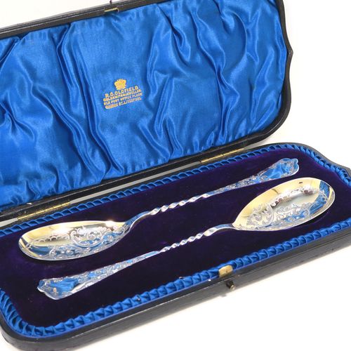 An extremely pretty pair of Antique Victorian Sterling Silver berry serving spoons, having hand-engraved handles and bowls with floral and scroll decoration, the bowls with a gold-gilt wash, and the handles with twisted middle sections, all in their original blue satin and velvet-lined presentation box. These beautiful silver serving spoons were made by the Atkin Brothers of Sheffield in 1900. The dimensions of this fine hand-made pair of antique silver berry spoons are length 21cms (8.3 inches), and they weigh a total of approx. 116g (3.7 troy ounces).  