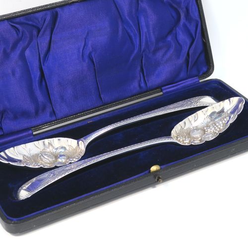 A very pretty pair of Antique Georgian Sterling Silver berry serving spoons, having hand-chased handles with zig-zag and floral decoration, and hand-chased bowls with fruit decoration, all in a dark blue satin and velvet-lined presentation box. These beautiful silver serving spoons were made by George Smith of London in 1774. The dimensions of this fine hand-made pair of antique silver berry spoons are length 21.5cms (8.5 inches), and they weigh a total of approx. 124g (4 troy ounces).   