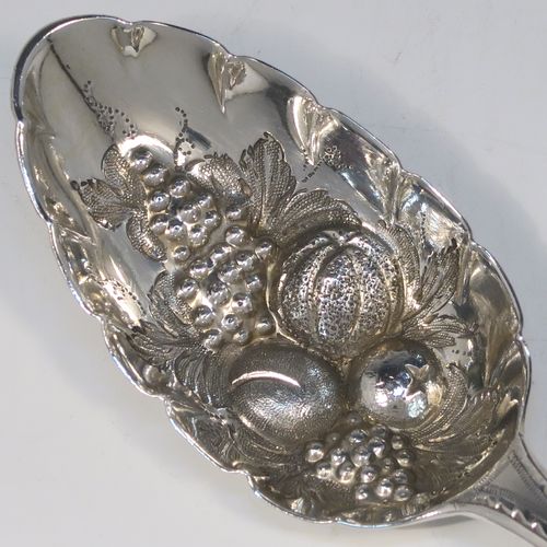 A very pretty pair of Antique Georgian Sterling Silver berry serving spoons, having hand-chased handles with zig-zag and floral decoration, and hand-chased bowls with fruit decoration, all in a dark blue satin and velvet-lined presentation box. These beautiful silver serving spoons were made by George Smith of London in 1774. The dimensions of this fine hand-made pair of antique silver berry spoons are length 21.5cms (8.5 inches), and they weigh a total of approx. 124g (4 troy ounces).   