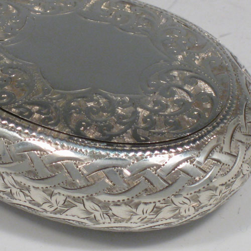    Antique Edwardian sterling silver squeeze-action tobacco box. Having an oval hand-engraved body and gold-gilt interior. Hallmarked for Birmingham in 1908. Length 8 cms (3 inches), width 6 cms (2.25 inches). Weight approx. 50g (1.6 troy ounces).