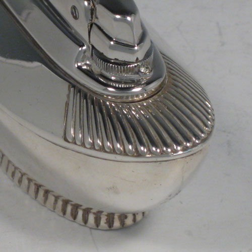    Sterling silver table lighter, having a plain oval lower body, with fluted shoulders, and sitting on a fluted collet foot. The lighter mechanism is by Ronson and is in fully working order. Length 11 cms (4.25 inches), height 6 cms (2.3 inches), width 4.5 cms (1.75 inches). Please note that this item is crested.