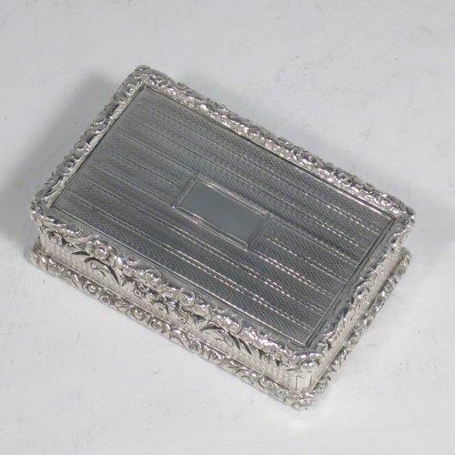 An Antique Georgian Sterling silver large and heavy snuff box, having a rectangular body with engine-turned decoration, with applied cast foliate thumb-piece and borders, and a gold-gilt interior. Made by John Bettridge of Birmingham in 1825. The dimensions of this fine hand-made antique silver snuff box are length 8 cms (3.25 inches), width 5 cms (2 inches), depth 2.5 cms (1.0 inches), and it weighs approx. 156g (5 troy ounces).   