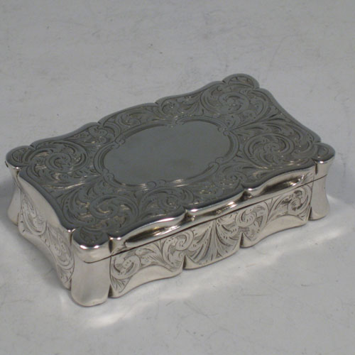 Antique Victorian sterling silver snuff box, having a shaped and hand-engraved body with floral decoration, gold-gilt interior, and hinged lid. Made by Hilliard and Thomason of Birmingham in 1852. Length 7.5 cms (3 inches), height 2 cms (0.75 inches), width 4.5 cms (1.75 inches). Weight approx. 85g (2.7 troy ounces).