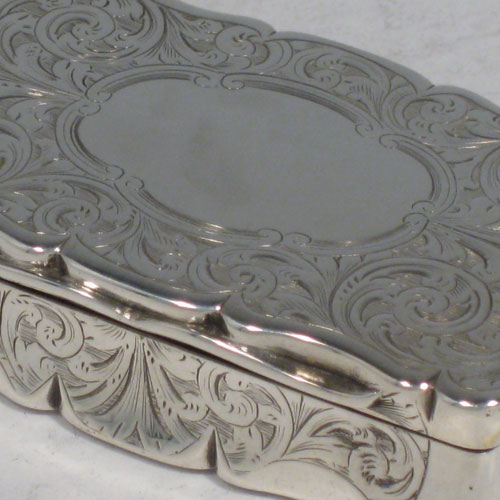 Antique Victorian sterling silver snuff box, having a shaped and hand-engraved body with floral decoration, gold-gilt interior, and hinged lid. Made by Hilliard and Thomason of Birmingham in 1852. Length 7.5 cms (3 inches), height 2 cms (0.75 inches), width 4.5 cms (1.75 inches). Weight approx. 85g (2.7 troy ounces).