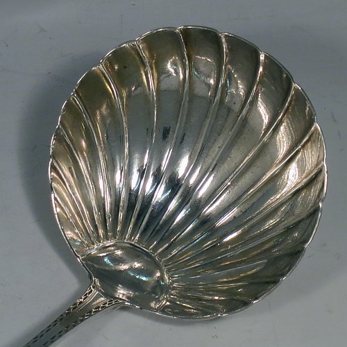 An Antique Georgian Sterling Silver large Irish soup ladle in the Irish Bright-Cut pattern, having a hand-engraved handle with bright-cut decoration, and a hand-chased shell style round bowl. Made in Dublin in 1794. The dimensions of this fine hand-made antique silver soup ladle are length 34 cms (13.3 inches), and it weighs approx. 159g (5.1 troy ounces). Please note that this item is crested.   