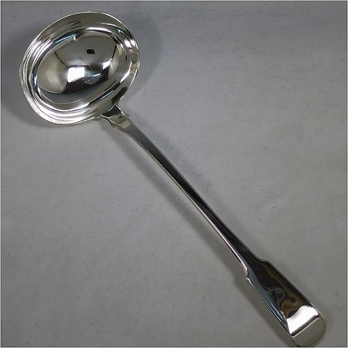 An Antique Georgian Sterling Silver soup ladle in the Fiddle pattern, having a plain handle with a pip on the reverse, and a plain round bowl with shoulders above and a heel on the reverse. Made by Sarah & John William Blake of London in 1820. The dimensions of this fine hand-made antique silver soup ladle are length 34 cms (13.5 inches), and it weighs approx. 280g (9 troy ounces). 