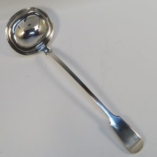 A heavy and elegant Antique Victorian Sterling Silver soup ladle in the Fiddle pattern, having a plain handle with a pip on the reverse, and a plain round bowl with shoulders above and a heel on the reverse. This handsome silver soup ladle was made by William Smiley of London in 1851. The dimensions of this fine hand-made antique silver soup ladle are length 36.5 cms (14.3 inches), and it weighs approx. 300g (9.7 troy ounces).   