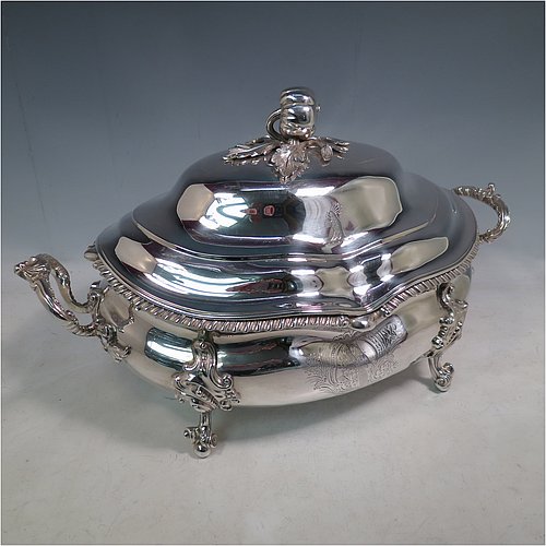 An Antique Early Victorian Sterling Silver soup tureen in a Regency style, having an oval bellied body with an applied wavy gadroon border, a domed pull-off cover with a cast pumpkin and leaf handle, with two cast scroll and shell side handles, and sitting on four cast scroll feet with floral shoulders. Made by William Moulson of London in 1840. The dimensions of this fine hand-made antique silver soup tureen and cover are length 43 cms (17 inches), height 25.5 cms (10 inches), width 24 cms (9.5 inches), and it weighs approx. 3,195g (103 troy ounces). Please note that this antique Victorian silver soup tureen is crested on the main body and cover.   