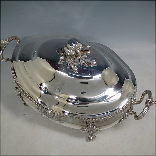 An Antique Early Victorian Sterling Silver soup tureen in a Regency style, having an oval bellied body with an applied wavy gadroon border, a domed pull-off cover with a cast pumpkin and leaf handle, with two cast scroll and shell side handles, and sitting on four cast scroll feet with floral shoulders. Made by William Moulson of London in 1840. The dimensions of this fine hand-made antique silver soup tureen and cover are length 43 cms (17 inches), height 25.5 cms (10 inches), width 24 cms (9.5 inches), and it weighs approx. 3,195g (103 troy ounces). Please note that this antique Victorian silver soup tureen is crested on the main body and cover.   