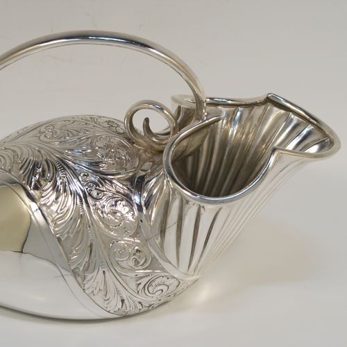 A beautiful and unusual Antique Victorian Silver Plated spoon warmer, in the shape of a fly trap pitcher plant, having a hand-chased body with fluted, leaf, and scroll decoration, and a scroll tendril handle. This pretty spoon warmer was made in ca. 1880 and has a design registration mark and a retailers mark for Glasgow. The dimensions of this fine hand-made antique silver-plated spoon warmer are length 20 cms (8 inches), height 10 cms (4 inches), and width 8.5 cms (3.3 inches).   