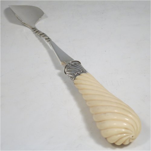 An Antique Victorian Sterling Silver and Ivory handled stilton cheese scoop, having a hand-cut spirally fluted handle, a hand-chased swirl-fluted ferrule, and a twisted stem with plain scoop. Made by William Hutton of London in 1899. The dimensions of this fine hand-made antique silver stilton cheese scoop are length 24 cms (9.5 inches).   