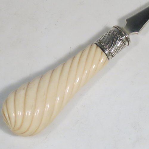 An Antique Victorian Sterling Silver and Ivory handled stilton cheese scoop, having a hand-cut spirally fluted handle, a hand-chased swirl-fluted ferrule, and a twisted stem with plain scoop. Made by William Hutton of London in 1899. The dimensions of this fine hand-made antique silver stilton cheese scoop are length 24 cms (9.5 inches).   