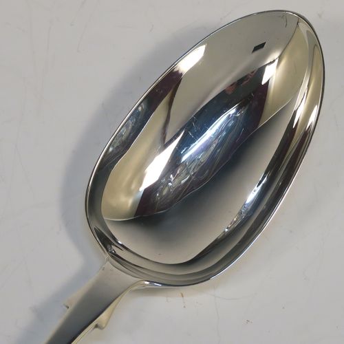 A handsome Antique Victorian Sterling Silver Fiddle pattern stuffing spoon, having a very plain handle with pip on reverse, and a plain oval bowl with shoulders above. This elegant antique silver serving spoon was made by the best Victorian flatware maker George Adams of London in 1854. The dimensions of this fine hand-made antique silver stuffing spoon are length 30.5 cms (12 inches), and it weighs approx. 122g (3.9 troy ounces).  