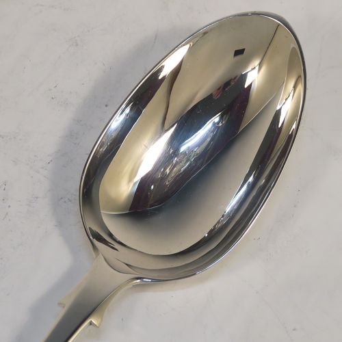 A handsome Antique Victorian Sterling Silver Fiddle pattern stuffing spoon, having a very plain handle with pip on reverse, and a plain oval bowl with shoulders above. This elegant antique silver serving spoon was made by the best Victorian flatware maker George Adams of London in 1884. The dimensions of this fine hand-made antique silver stuffing spoon are length 30.5 cms (12 inches), and it weighs approx. 130g (4.2 troy ounces).   