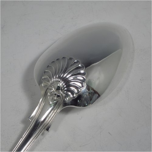 An Antique Georgian sterling silver stuffing spoon in the double-struck Kings pattern, having a fancy handle with hand-chased shell, scroll, and reeded decoration, and a plain oval bowl with shoulders above. Made by William Eley & William Fearn of London in 1823. The dimensions of this fine hand-made silver stuffing spoon are length 31 cms (12.25 inches), and it weighs approx. 200g (6.5 troy ounces).