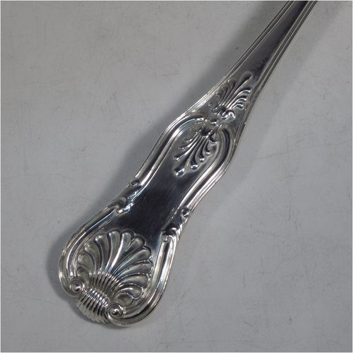 An Antique Georgian sterling silver stuffing spoon in the double-struck Kings pattern, having a fancy handle with hand-chased shell, scroll, and reeded decoration, and a plain oval bowl with shoulders above. Made by William Eley & William Fearn of London in 1823. The dimensions of this fine hand-made silver stuffing spoon are length 31 cms (12.25 inches), and it weighs approx. 200g (6.5 troy ounces).