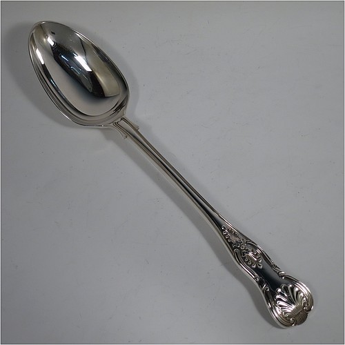 A heavy Sterling Silver stuffing spoon in the double-struck Kings pattern, having a fancy handle with hand-chased shell, scroll, and reeded decoration, and a plain oval bowl with shoulders above, and shell on reverse. Made in London in 1978. The dimensions of this fine hand-made silver stuffing spoon are length 31 cms (12.25 inches), and it weighs approx. 253g (8.2 troy ounces).   